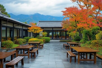 Fototapeta premium A mountain forms the background of a Japanese garden that contains a wooden table and chairs