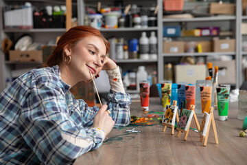 A Creative Artist Working Enthusiastically in a Colorful Studio Surrounded by Paint Tubes