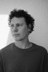 Curly Haired Man Eating an Apple with Emotional Expression – Black and White Artistic Portrait