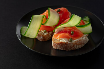 Sandwiches with smoked trout, cream cheese, fresh cucumber, and capers.
