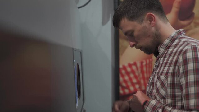 Man returns plastic bottles to reverse vending machine in supermarket. This recycling system promotes eco-friendly habits sustainability and waste reduction through deposit refunds for bottle returns