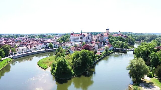 Eine beeindruckende Luftaufnahme von Neuburg an der Donau, einer malerischen Stadt in Bayern, Deutschland. Die Donau schl&auml;ngelt sich durch die Stadt und bildet eine kleine Insel.