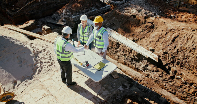 Construction team, handshake and engineer people in partnership outdoor with foundation blueprint. Men, women or above employees with deal for excavation, agreement or architecture with shaking hands