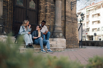 Students relaxing and chatting on university steps after classes