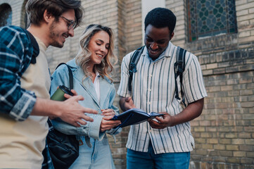Students consulting a notebook while visiting a city