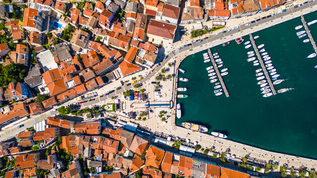 Daytime aerial view of Mali Lo&scaron;inj (Losinj), Croatia, featuring Župna crkva rođenja Blažene Djevice Marije and charming coastal architecture along the Adriatic Sea. A peaceful and sunny island scene