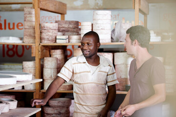 Pottery, ceramic and men in workshop talking for small business, startup and creative store. Meeting, art studio and people in discussion with inventory for clay object, craft and design on shelf