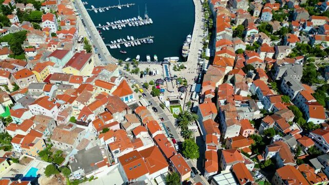 Daytime aerial view of Mali Lo&scaron;inj (Losinj), Croatia, featuring Župna crkva rođenja Blažene Djevice Marije and charming coastal architecture along the Adriatic Sea. A peaceful and sunny island scene