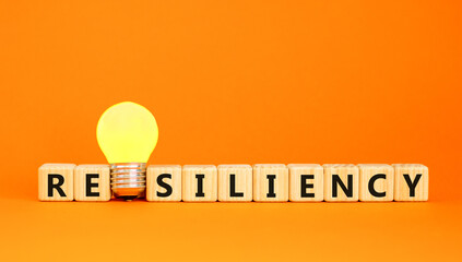 Resiliency symbol. Concept word Resiliency on beautiful wooden blocks. Beautiful orange table...