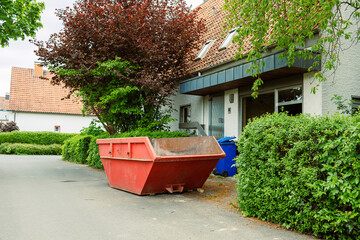Large street garbage container. Metal red container for construction waste. Garbage container...