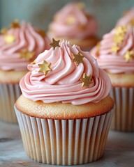 Pink frosted cupcakes with gold star sprinkles.  Close-up view of delicious treats