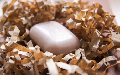 Natural organic soap bar on paper shavings background.