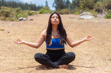 Young woman meditating outdoors in a peaceful natural setting