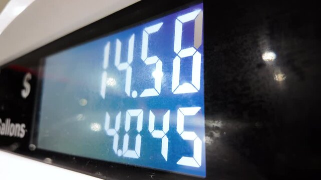 Petrol station with running numbers on gas pump at night time. Close up 