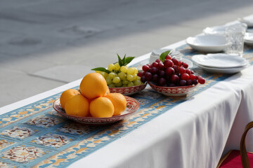 wes andersonstyle photograph tables set for friendly lunch adorned with mosaic patterns and exotic fruits
