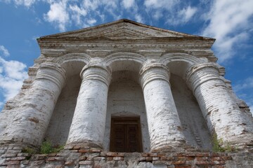 Fototapeta premium Whitewashed Brick Temple: Classical Columns under a Blue Sky