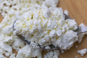 Fresh Crumbled White Cheese on a Spoon, Ready for Cooking or Serving