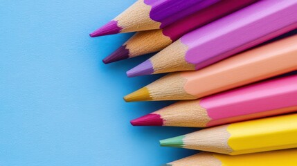 Fototapeta premium Colorful pencils arranged on a blue background