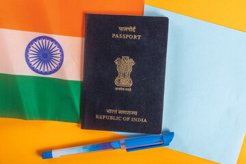 Indian passport is displayed with the national flag and office supplies against a bright background.
