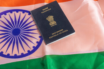 Indian passport is placed on top of the Indian national flag, representing the concept of identity and travel.