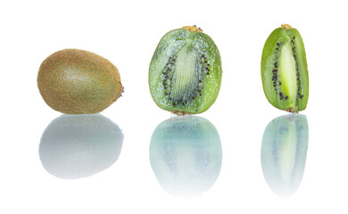 Fresh kiwi trio: one whole fuzzy kiwi, one halved to reveal vibrant green flesh and black seeds, and one vertically sliced. Glossy reflection enhances the shot