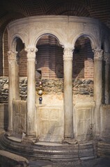 Fototapeta premium Beneath the ethereal light, intricately carved marble columns rise gracefully in a historic structure in Zakynthos, Greece. The remnants exude timeless beauty and mystery, inviting exploration