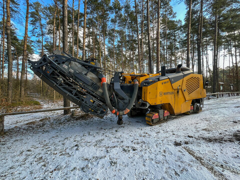 An asphalt milling machine in a parking lot, waiting to remove part of the road surface during the construction of a sewage system