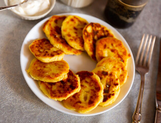 Popular curd dish of Russian cuisine called cheese pancakes, prepared with the addition of eggs and flour, served with sour ..cream