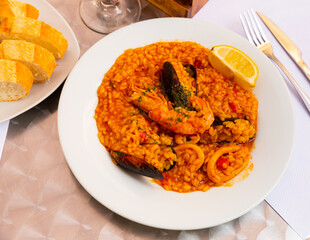 Traditional delicious dish of Spanish cuisine is paella with seafood, made from rice, vegetables, shrimp, squid and ..mussels