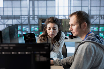 Team leader showing intern how to use machine learning to optimize data center operations. Close up...