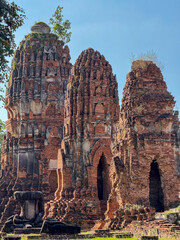 Fototapeta premium Majestic religious Thai landmark with many Buddha statues along the temple walls, Wat Maha That Buddhist ancient structure offer a serene sacred atmosphere. Cultural heritage monument.