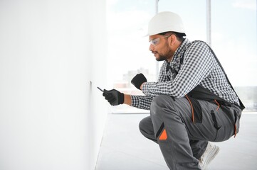 Indian Worker spreading plaster to wall with trowel, repairing works