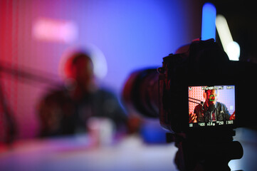 Male lifestyle vlogger recording live podcast vlog on camera