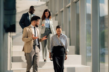 Business people walking down stairs in modern office building