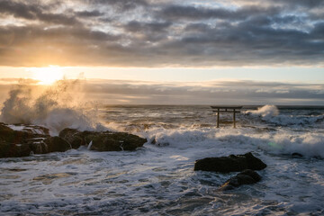 荒れる海と日の出直後の神磯の鳥居
