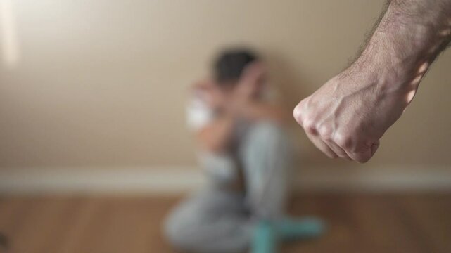 Man is holding child's hand. A child is fisting at a parent. Family members fear violence in the corner. A man is grasping a lifestyle child's hand.