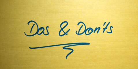 Dos and Don'ts. Yellow note with handwritten text. Advice or rules.