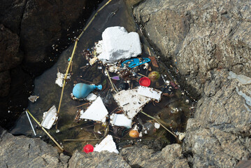 view of garbage discarded in the water on the edge of Rio Vermelho beach in the city of Salvador,...