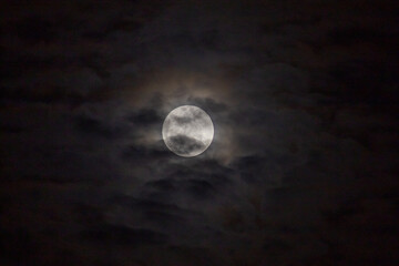 Full moon in the night sky with clouds