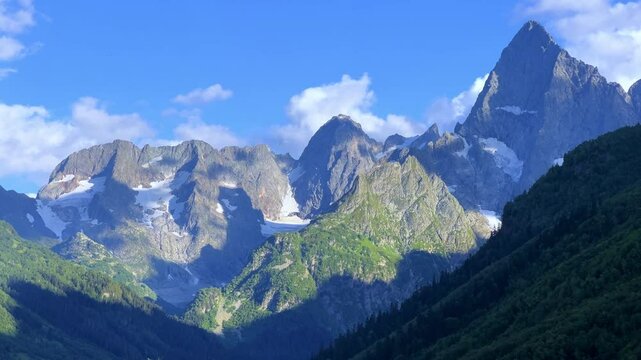 Teberdinsky Nature Reserve. View of Kosygin's glade in the Gonachkhir gorge and the top of Dombai-Ulgen mountain near Lake Tumanly-Kel on a sunny summer day. Panoramic landscape. Resort. 4K