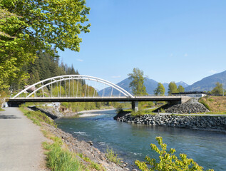 Obraz premium Vedder Bridge across Chilliwack River as seen from the Vedder Rotary Trail North during a spring season in Chilliwack, Fraser Valley, British Columbia, Canada
