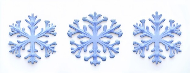 Fototapeta premium Three light blue decorative snowflakes arranged horizontally on a white background symbolizing winter and holiday cheer