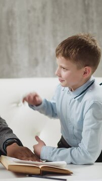 Cheerful African-American tutor gives high five and shows thumb-up praising junior boy student at private English tuition with native speaker slow motion