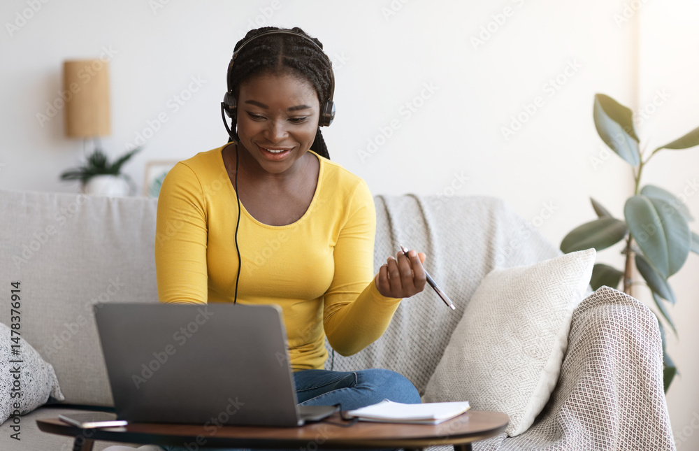 Aufkleber millennial african lady in headset watching webinar on laptop at home, having online training, study