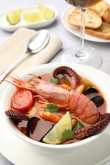 Tasty seafood soup served on light grey table, closeup