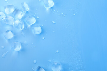 Cubes of clear ice on light blue background, flat lay. Space for text