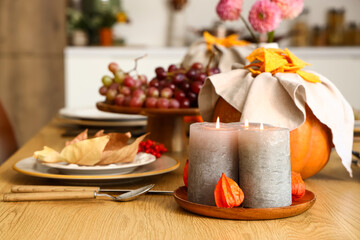 Autumn table setting with pumpkins, grapes and dry leaves
