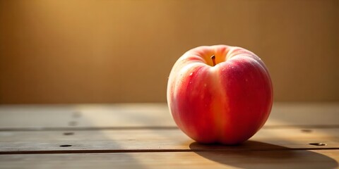 A velvety ripe peach resting on a wooden table with soft natural window light casting gentle shadows. The background is warm and creamy with a farmhouse-style blur. Water droplets lightly cover the pe