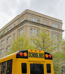 School bus parked in front of school in Brooklyn New York City. Yellow back to school ride.