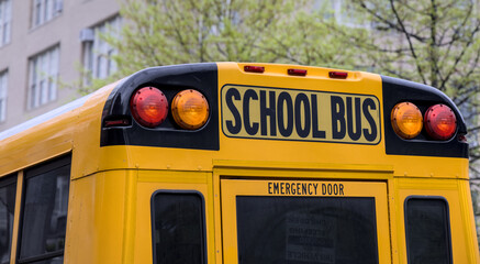 School bus parked in front of school in Brooklyn New York City. Yellow back to school ride.